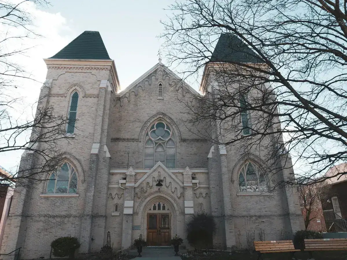 Church exterior with twin towers, arched windows, and a central entrance