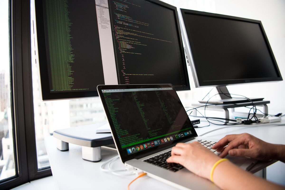 Software professionals collaborating around laptops in a modern office